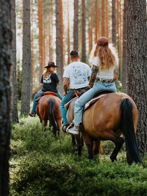 Ryttare längs en stig i tallskogen.